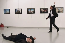 Hung thủ Mevlut Altintas (phải) sau khi sát hại Đại sứ Nga Andrei Karlov (trái) ở Ankara, Thổ Nhĩ Kỳ ngày 19/12/2016. (Ảnh: AFP/TTXVN)