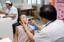 Bác sỹ Bệnh viện Nhi đồng 1 Thành phố Hồ Chí Minh thăm khám cho trẻ. (Ảnh: Phương Vy/TTXVN)