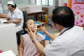 Bác sỹ Bệnh viện Nhi đồng 1 Thành phố Hồ Chí Minh thăm khám cho trẻ. (Ảnh: Phương Vy/TTXVN)