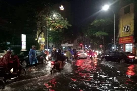 Mưa ngập gây cản trở giao thông tại ngã tư Thợ Nhuộm-Quán Sứ. (Ảnh: Trọng Đạt/TTXVN)