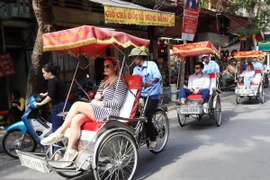 Du khách quốc tế thăm Hà Nội bằng xích lô. (Ảnh: Anh Tuấn/TTXVN)