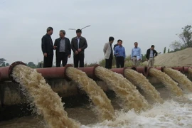 Lãnh đạo Sở Nông nghiệp và Phát triển Nông thôn Hà Nội kiểm tra lấy nước ở trạm bơm Ấp Bắc. (Ảnh: Đỗ Phương Anh/TTXVN)