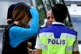 Nghi phạm Đoàn Thị Hương (giữa, trái) được áp giải tới tòa án ở Sepang, Malaysia ngày 30/5 vừa qua. (Ảnh: AFP/TTXVN)