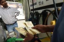 Khách hàng đổ xăng tại một trạm xăng ở New Delhi, Ấn Độ. (Ảnh: AFP/TTXVN)