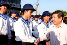 Chủ tịch UBND Thành phố Hồ Chí Minh Nguyễn Thành Phong chúc mừng và động viên các thanh niên trúng tuyển nghĩa vụ quân sự tại điểm giao quân Quận 9, TP.HCM. (Ảnh: Thế Anh/TTXVN)