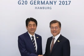 Thủ tướng Nhật Bản Shizo Abe (ảnh, trái) và Tổng thống Hàn Quốc Moon Jae In (ảnh, phải) có cuộc gặp song phương bên lề Hội nghị G20. (Ảnh: Yonhap/TTXVN)