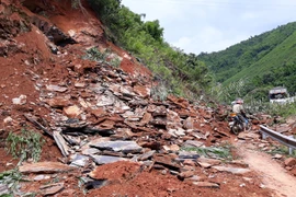 Một khối lượng lớn đất đá sạt lở đã khiến giao thông bị tê liệt. (Ảnh: Nguyễn Chiến/TTXVN)