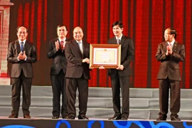 Thủ tướng Nguyễn Xuân Phúc thừa ủy quyền Chủ tịch nước trao tặng Huân chương Độc lập hạng Nhất cho tỉnh Quảng Nam. (Ảnh: Thống Nhất/TTXVN)