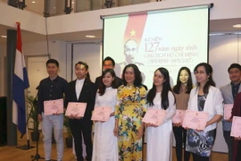 Đại sứ Ngô Thị Hoà trao bằng khen cho 17 sinh viên Việt Nam có thành tích xuất sắc. (Ảnh: Định Hương/TTXVN)