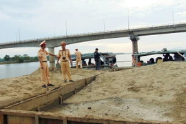 Lực lượng cảnh sát đường thủy đưa tàu về nơi tập kết tang vật . (Ảnh: Nguyễn Sơn/TTXVN)