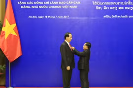 Đồng chí Phankham Viphavan, Ủy viên Bộ Chính trị,Thường trực Ban Bí thư Đảng NDCM Lào, Phó Chủ tịch nước Lào trao tặng Huân chương Vàng Quốc gia của Đảng, Nhà nước Lào cho Chủ tịch nước Trần Đại Quang. (Ảnh: Nhan Sáng/TTXVN)