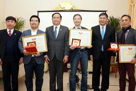 Phó Chủ tịch Ủy ban Trung ương Mặt trận Tổ quốc Việt Nam Trần Thanh Mẫn tặng bằng khen cho tập thể, cá nhân kiều bào có nhiều đóng góp vào hoạt động an sinh xã hội năm 2016. (Ảnh: Phạm Văn Thắng/TTXVN) 