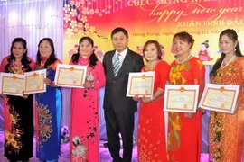 Tổng lãnh sự Hoàng Chí Trung (giữa) chụp ảnh cùng kiều bào ưu tú. (Ảnh: Xuân Tuấn/Vietnam+)