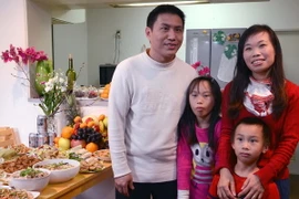 Gia đình anh Sơn bên mâm cơm tất niên. (Ảnh: Gia Quân/Vietnam+)