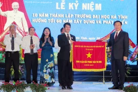 Phó Thủ tướng Vương Đình Huệ tặng Cờ thì đua của Chính phủ cho nhà trường. (Ảnh: Công Tường/TTXVN)
