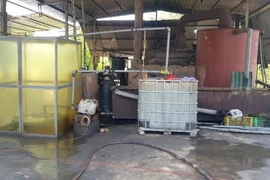 Toàn bộ quy trình tái chế nhớt thải trái phép thực hiện bằng phương pháp thủ công, lộ thiên qua đun nấu kết hợp với pha chế hóa chất độc hại. (Ảnh: TTXVN phát)