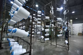 Công nhân làm việc tại nhà máy sợi Huế thuộc Công ty Cổ phần Dệt may Huế (Thừa Thiên-Huế). (Ảnh: TTXVN)