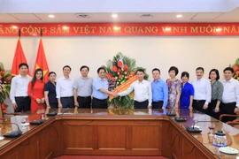 Thứ trưởng Bộ Văn hóa, Thể thao và Du lịch Tạ Quang Đông (bên trái) chúc mừng Thông tấn xã Việt Nam. (Ảnh: Dương Giang/TTXVN)