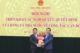 Bí thư Trung ương Đảng, Trưởng Ban Tuyên giáo Trung ương Nguyễn Trọng Nghĩa tặng hoa và chúc mừng Tân Bộ trưởng Bộ Công Thương Nguyễn Hồng Diên. (Ảnh: Đức Duy/Vietnam+)