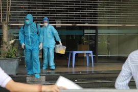 Cơ quan chức năng thực hiện các biện pháp y tế tại một tòa nhà của Bộ Công Thương do liên quan đến ca F0 đến làm việc. (Ảnh: Phan Lâm/Vietnam+)