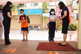 Học sinh được hướng dẫn các biện pháp phòng, chống dịch bệnh khi đến lớp. (Ảnh: TTXVN)