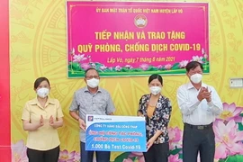Chủ tịch kiêm Giám đốc Petrolimex Đồng Tháp Lê Phúc Thạnh trao 1.000 bộ test nhanh COVID-19 tới Ủy ban Mặt trận Tổ quốc huyện Lấp Vò. (Ảnh: PV/Vietnam+)