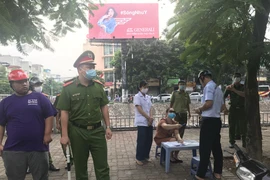 Lực lượng chức năng của Hà Nội xử phạt người không đeo khẩu trang tại nơi công cộng. (Ảnh: Đức Duy/Vietnam+)