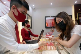 Khách hàng giao dịch vàng miếng. (Ảnh: TTXVN)
