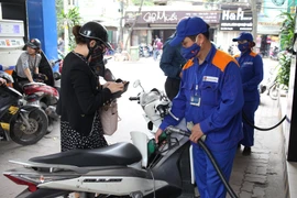 Nhân viên Petrolimex đang bán xăng cho khách hàng. (Ảnh: Đức Duy/Vietnam+)