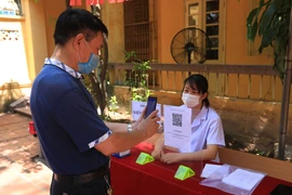 Người dân thực hiện khai báo y tế. (Ảnh: Xuân Quảng/Vietnam+)