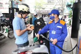 Nhân viên Petrolimex đang bán xăng cho khách hàng. (Ảnh: Đức Duy/Vietnam+)