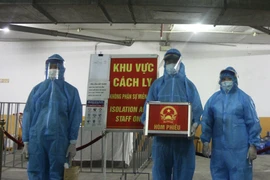 Chuẩn bị các bước theo đúng quy định trước khi vào khu cách ly tập trung. (Ảnh: Tá Hiển/Vietnam+)