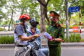 Lực lượng chức năng kiểm tra các phương tiện lưu thông trong thời gian giãn cách xã hội. (Ảnh: TTXVN)