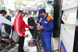 Nhân viên Petrolimex đang bán xăng cho khách hàng. (Ảnh: Đức Duy/Vietnam+)