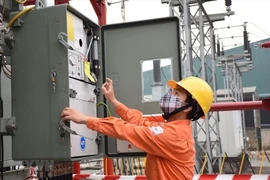 Nhân viên EVNHANOI kiểm tra tình trạng vận hành của thiết bị điện. (Ảnh: PV/Vietnam+)