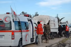 Nhân viên Hội Lưỡi liềm đỏ Syria hỗ trợ người dân sơ tán vùng chiến sự tới khu vực do quân đội kiểm soát ở thành phố Homs ngày 10/2 vừa qua. (Ảnh: AFP/TTXVN)