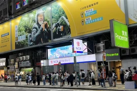 Người dân xếp hàng chờ xe buýt tại Hong Kong ngày 23/4. (Ảnh: Mạc Luyện/TTXVN)