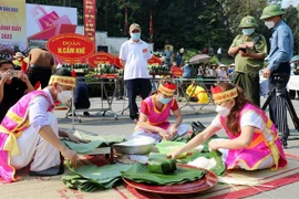 Đội thi gói, nấu bánh chưng huyện Cẩm Khê thực hiện phần thi gói bánh chưng. (Ảnh: Trung Kiên/TTXVN)