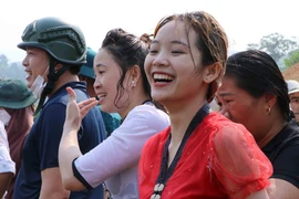 Một cô gái Thái vui vẻ dù bị ướt. (Ảnh: Nguyễn Oanh/TTXVN)