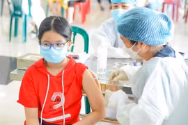 Nhân viên y tế tiêm vaccine cho các em học sinh. (Ảnh: Văn Dũng/TTXVN)