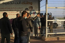 Người lao động Palestine chờ qua cửa khẩu Erez vào Israel ngày 23/2. (Ảnh: AFP/TTXVN)