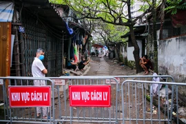 Ngay trong tối 11/3 khi nhận được thông tin có người bị nghi nhiễm COVID-19 lực lượng chức năng phường Dịch Vọng (Quận Cầu Giấy, Hà Nội) đã tiến hành phong toả khu vực ngõ 165 Cầu Giấy. (Ảnh: Minh Sơn/Vietnam+)