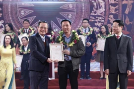 Phó Chủ tịch Quốc hội Phùng Quốc Hiển và Bộ trưởng Bộ Thông tin và Truyền thông Nguyễn Mạnh Hùng trao giải C cho các tác giả. (Ảnh: Dương Giang/TTXVN)