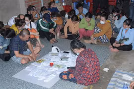 Các đối tượng đánh bạc bị bắt quả tang tại hiện trường. (Ảnh: TTXVN phát)