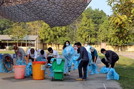 Công dân về từ nước ngoài bỏ đồ bảo hộ y tế để tập trung. (Ảnh: Thanh Hải/TTXVN)