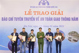 Thiếu tướng Nguyễn Duy Ngọc, Thứ trưởng Bộ Công an, Phó Chủ tịch Ủy ban An toàn giao thông Quốc gia trao giải Nhì cho các tác giả. (Ảnh: Doãn Tấn/TTXVN)