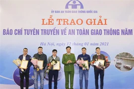 Thiếu tướng Nguyễn Duy Ngọc, Thứ trưởng Bộ Công an, Phó Chủ tịch Ủy ban An toàn giao thông Quốc gia trao giải Nhì cho các tác giả. (Ảnh: Doãn Tấn/TTXVN)