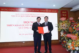 Ông Hà Ban, Ủy viên Trung ương Đảng, Phó Trưởng Ban Tổ chức Trung ương trao quyết định bổ nhiệm ông Phạm Minh Tuấn giữ chức Giám đốc kiêm Tổng Biên tập Nhà xuất bản Chính trị quốc gia Sự thật. (Ảnh: Phương Hoa/TTXVN)