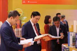 Đại biểu xem các cuốn sách tiêu biểu tại không gian trưng bày sách, báo phục vụ Đại hội XIII. (Ảnh: TTXVN)