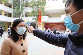 Trường THPT Trần Nhân Tông, quận Hai Bà Trưng (Hà Nội) thực hiện đo thân nhiệt, sát khuẩn tay cho cán bộ, giáo viên và học sinh mỗi khi ra, vào trường (ảnh chụp sáng 29/1). (Ảnh: Thanh Tùng/TTXVN)